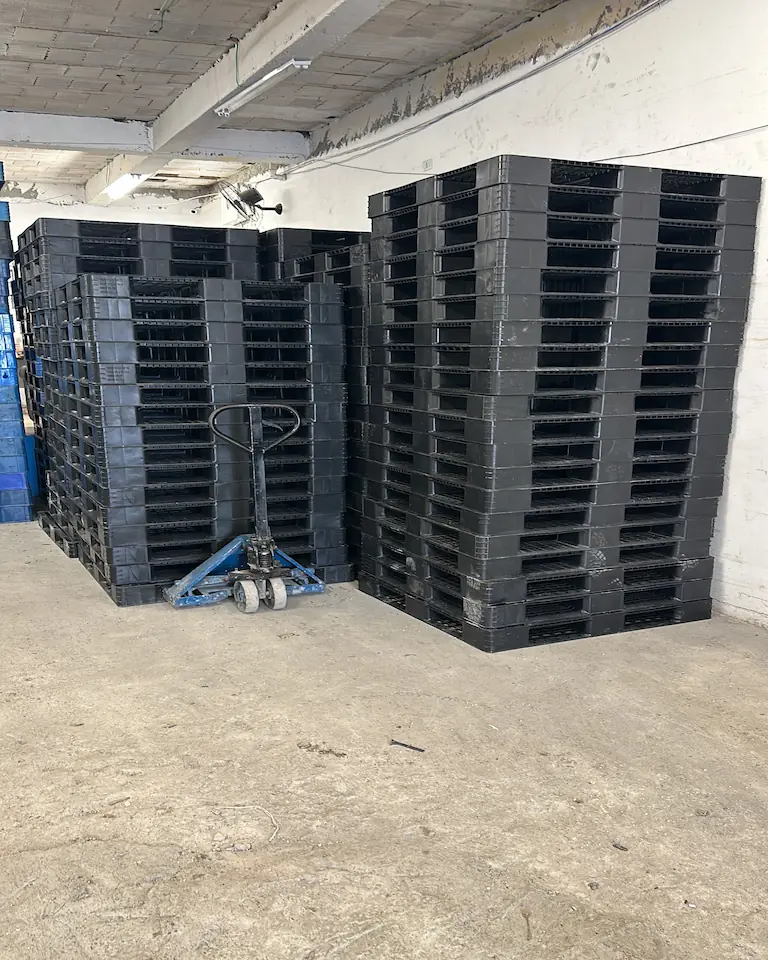 Área de estoque com pallets de plástico empilhados