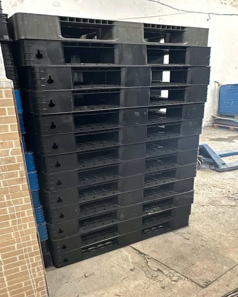 Pallets de plástico empilhados no pátio da Sampaio Paletes